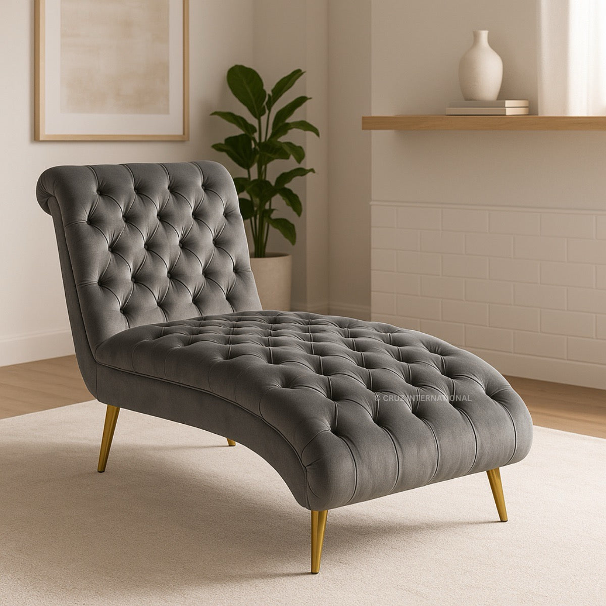 Gray tufted chaise lounge in a room with a plant and shelf.